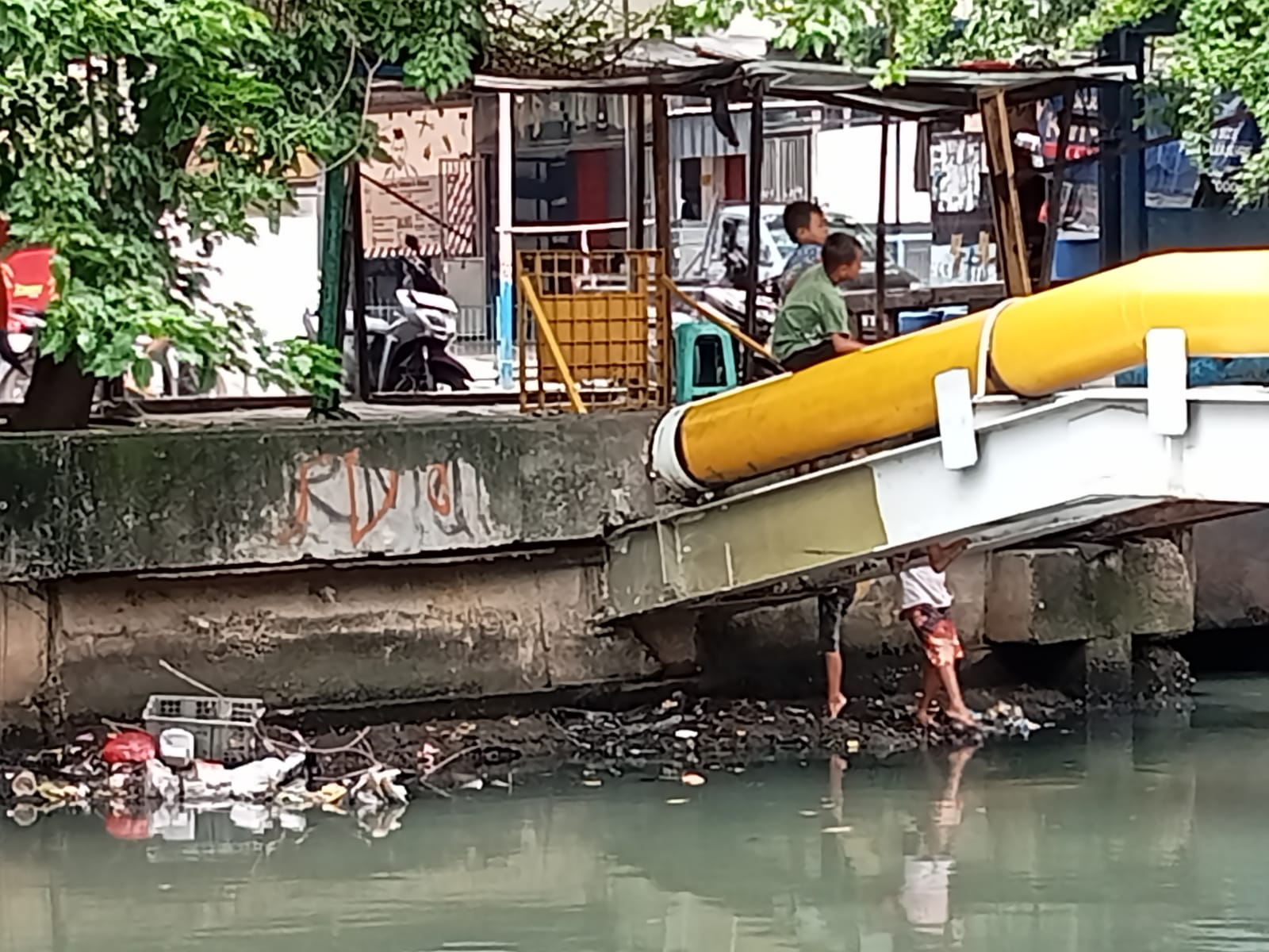 Beberapa anak kecil bermain di bantaran Sungai Angke teluk Gong, Penjaringan, Jakarta Utara tanpa takut, anak-anak tersebut memacing ikan di sungai berbau menyengat (DP.Sari/Prohealth,id)